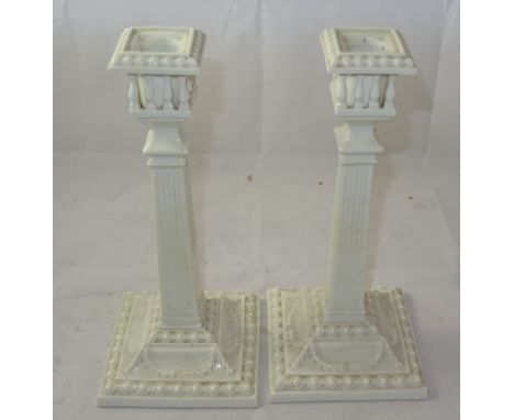 A pair of Royal Worcester blanc de chine candlesticks