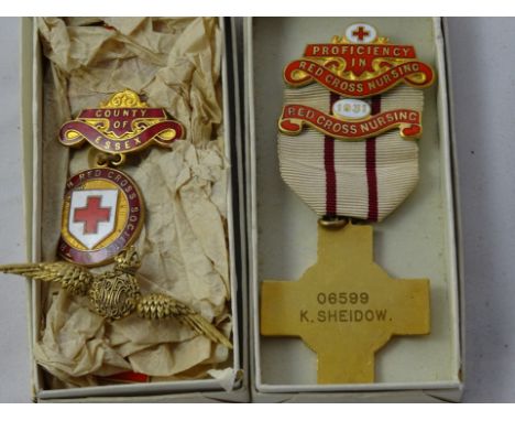 Two enamel red cross medals; together with a brooch