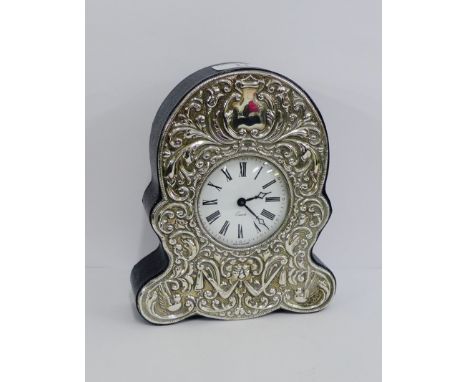 A contemporary silver and leather cased clock, the front with repousee decoration surrounding the white enamel dial with Roma