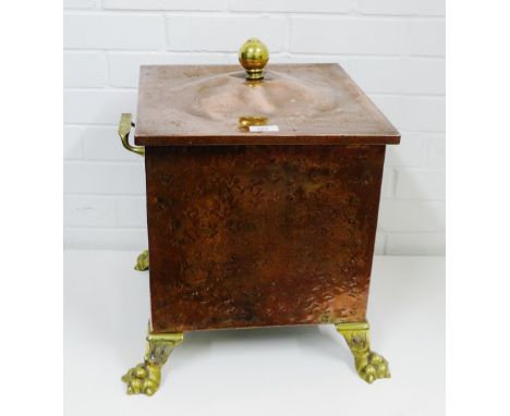 A copper and brass coal bucket of square form with twin handles to side and a brass finial to the lid on four hairy paw feet,