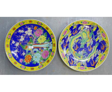 Two oriental large circular chargers painted in enamel depicting Dragons and Birds, 45cm diameter