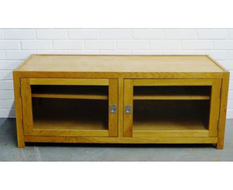 A modern light wood cabinet with twin glazed doors and internal shelf, 50 x 128cm