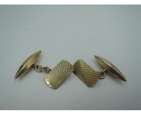 A pair of 9ct gold cufflinks having engine turned rectangular plaques with chain connectors to lozenge shaped backs, approx 4