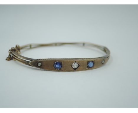 A Victorian 9ct rose gold hinged bangle having sapphire and diamond set lozenge shaped panel and concealed clasp, Chester hal