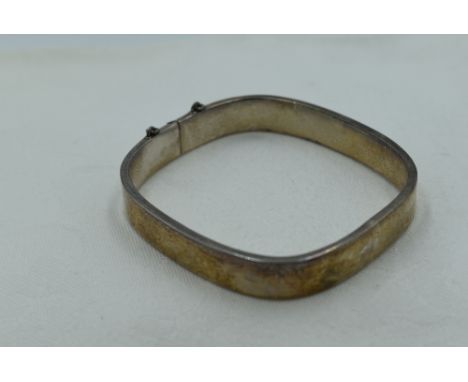 A silver hinged bangle of plain canted square form, missing safety chain, approx 15g
Condition Report
The safety chain is mis