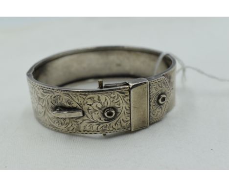 A 1950's silver hinged belt bangle having engraved scroll decoration, approx 25.1g, (missing buckle)
As photo shows buckle at