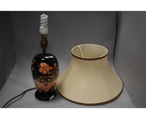 A Moorcroft pottery ovoid table lamp, tube-lined in the Oberon pattern against the washed cobalt to peach ground, with wooden