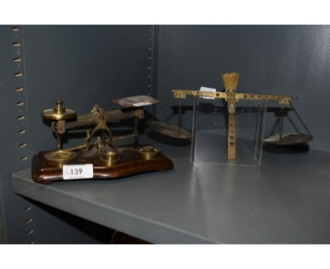 A set of vintage postal scales with a similar partial set and some brass weights.