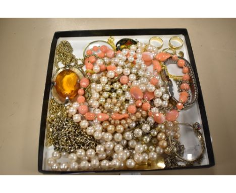 A selection of vintage costume jewellery including simulated pearls, brooches and a monocle.