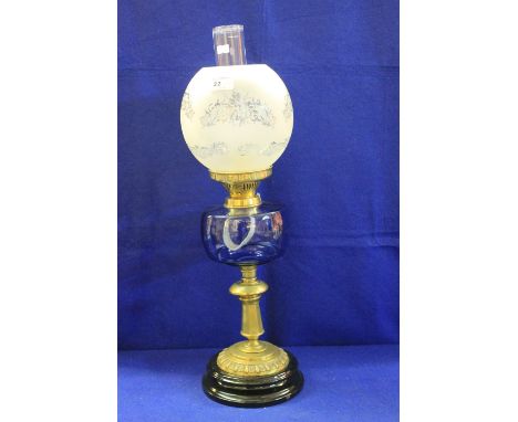 Late 19th century brass double burner oil lamp with coloured glass reservoir and brass pedestal base on ceramic platform, wit
