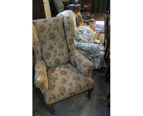 Pair of late Victorian foliate tapestry upholstered winged fireside chairs with vase shaped front legs on ceramic casters. (2