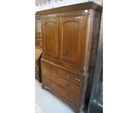 Early 19th century Welsh oak two stage linen press having moulded cornice over blind panel arched doors with quarter pilaster