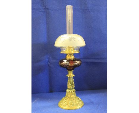 19th century brass single burner oil lamp, with flash cut ruby glass reservoir on a foliate and berry decorated relief pedest