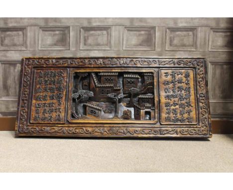 MID 20TH CENTURY CHINESE CARVED WOOD WALL PANEL the central panel depicting an architectural landscape scene, with script eit