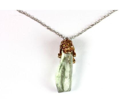 A white metal (tested silver) gilded skull set with peridot and amethyst including a large rock crystal on a 925 silver chain