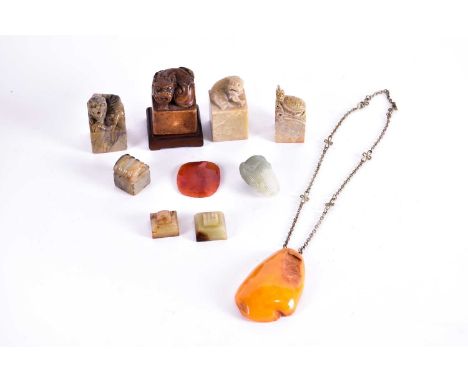 Three Chinese jade seals, a small jade carving of a fish above a pierced basket, a red agate peony pendant, a butterscotch am