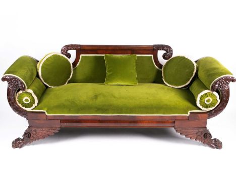 A 19th century probably American 'Empire' style mahogany scroll end sofa, with carved stuff over upholstered show frame, on b