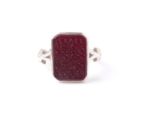 An Eastern white metal gentleman's dress ring with intaglio carved Islamic calligraphy rectangular carnelian(?) panel.Conditi