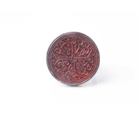 A probably Persian white metal gentleman's ring set with a circular bloodstone(?) panel engraved in the round with Arabic cal