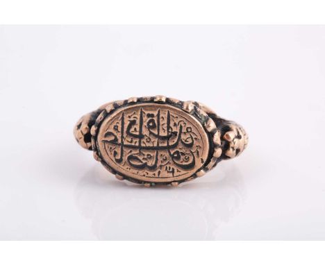 A Persian gold coloured metal gentleman's ring, in the early Qajar style, engraved with calligraphy.