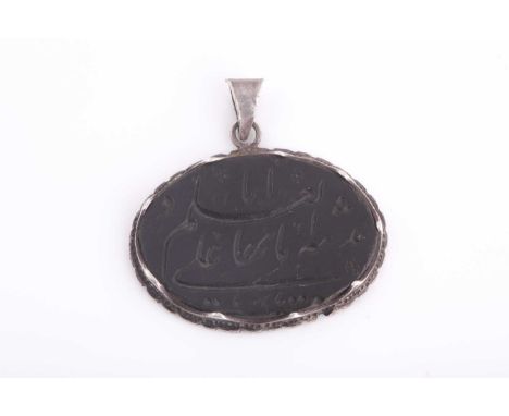 A Safavid carved dark green jade pendant in silver metal mount, of oval form, engraved with calligraphy, with silver metal su