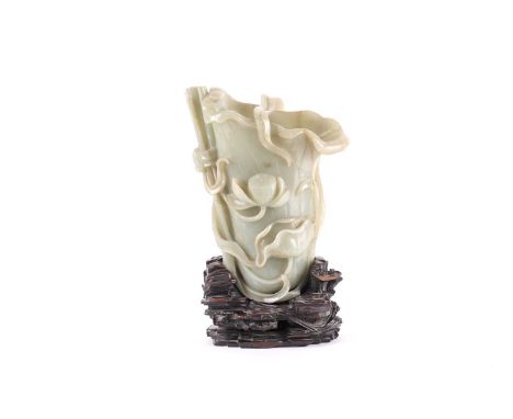 A large Chinese carved celadon jade Rhyton, possibly late Qing dynasty. In the form of a lotus flower and tied reed with seed