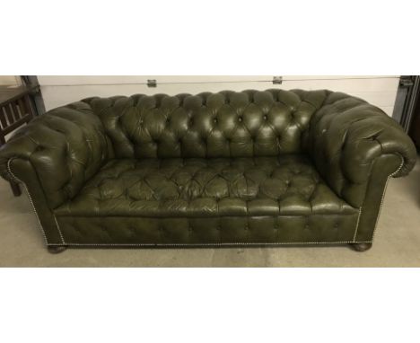 A vintage green leather 2/3 seater chesterfield settee. With wooden feet and ceramic castors, stud work detail to front. Appr