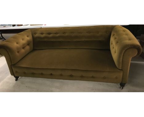 A vintage brown velvet upholstered chesterfield settee. With ceramic castors on wooden feet. Approx. 220cm long. Please Note: