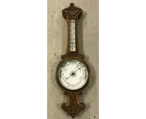 A vintage barometer with carved decoration and thermometer. Cracks to enamel barometer face (not glass). 84cm long. Please No