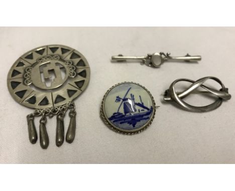 4 silver brooches including one with a delft ceramic cabochon.  Please Note: All enquiries will be responded to after we re-o