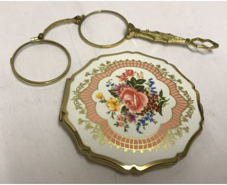 A pair of fold-away pince nez with release button on the side. Together with a Stratton powder compact with floral design to 