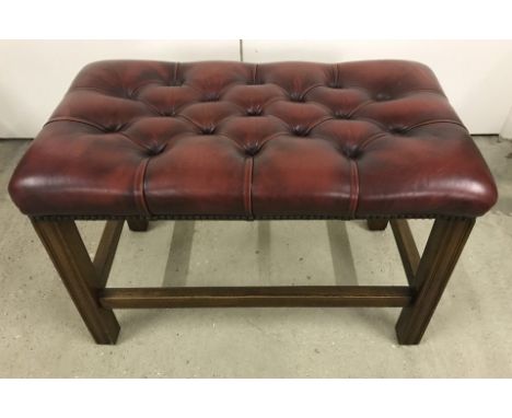 A double Chesterfield stool with dark oak frame and oxblood red button leather seat.  Approx. 46cm tall x 70cm wide. Please N