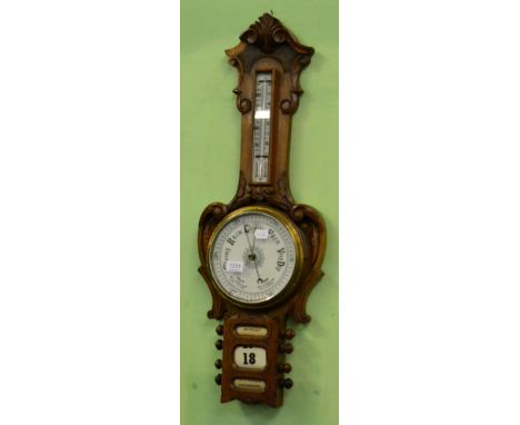 An oak aneroid barometer with combined calendar displays 