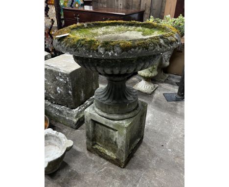 A reconstituted stone circular campana planter on square plinth, diameter 80cm, height 102cm