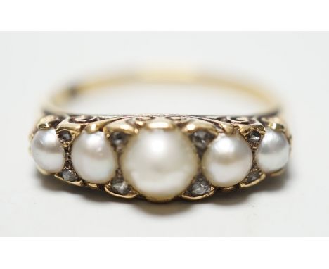 A late Victorian yellow metal (stamped 18) and five stone graduated split pearl set half hoop ring, with diamond chip spacers