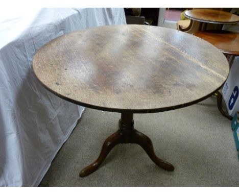 AN ANTIQUE OAK TILT TOP TRIPOD TABLE, 72 cms high, 80 cms diameter the top (catch button absent restricting the tilt action)