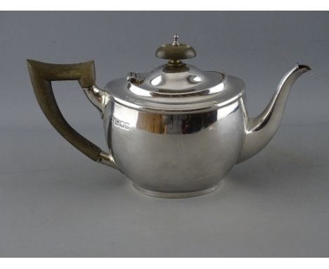 A BACHELOR'S SILVER TEAPOT, London 1917, maker Carrington &amp; Co, with composite handle and lid finial, 22.5 cms long, 11 t