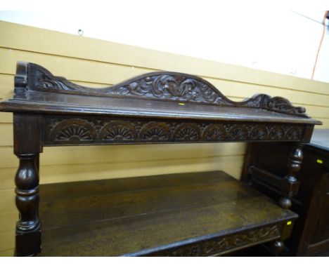 A VINTAGE OAK HALL BENCH having a shaped back and side rails with carved detail on block and turned supports, 58 cms high max