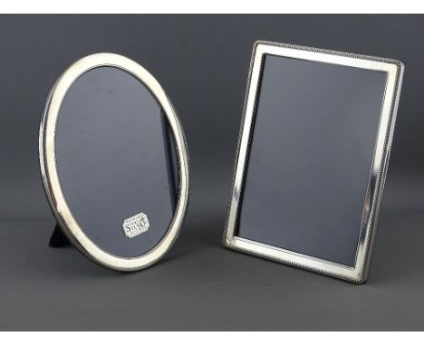 TWO MODERN HALLMARKED SILVER EASEL PHOTOGRAPH FRAMES to include a 20.5 x 15.5 cms oval, Sheffield 1997 and a 20.5 x 15.5 cms 
