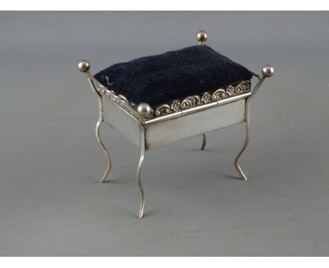 A VELVET TOPPED SILVER TRINKET BOX with mirrored interior in the form of a box seat piano stool, 8 cms long, Birmingham 1909,