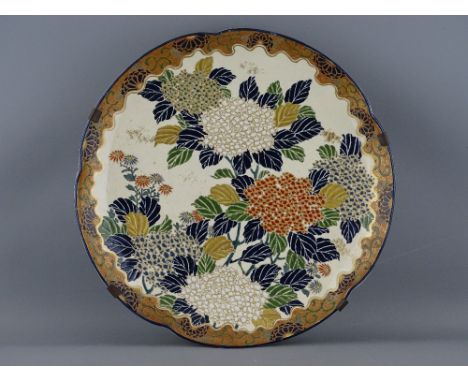 AN EARLY 20th CENTURY JAPANESE SATSUMA POTTERY WALL CHARGER having enamel decorated floral pattern in relief with gilt highli