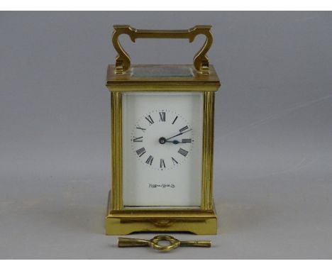 A MAPPIN &amp; WEBB BRASS CASED CARRIAGE CLOCK with key, the dial set with Roman numerals, 15 cms high (handle up)