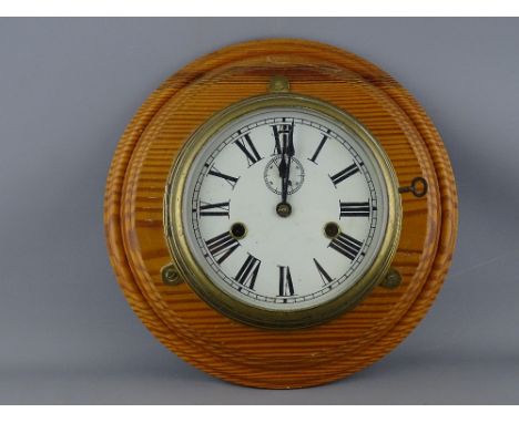 A BRASS SHIP'S BULKHEAD CLOCK, painted 7 ins dial set with Roman numerals, subsidiary seconds dial and fast/slow adjuster bef