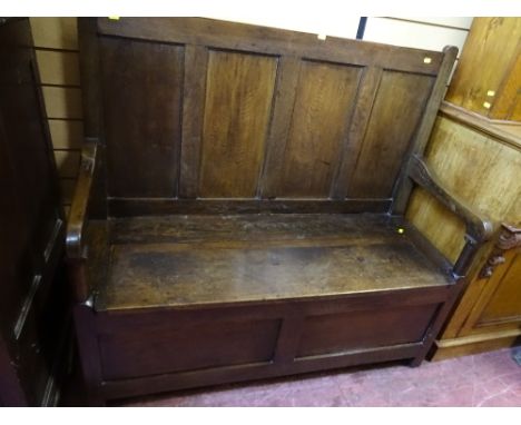 A 19th CENTURY OAK BOX SEAT HALL BENCH, peg joined construction with panelled back and swept arms on stile feet, 110 cms high