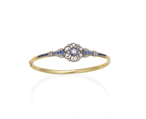 An early 20th century sapphire and diamond bangleDesigned as an openwork flowerhead millegrain-set with calibré-cut sapphires