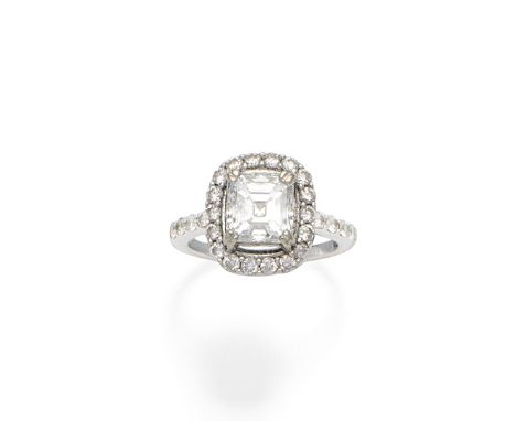 A diamond cluster ringThe step-cut diamond weighing 2.45 carats, within a brilliant-cut diamond surround, the shoulders simil