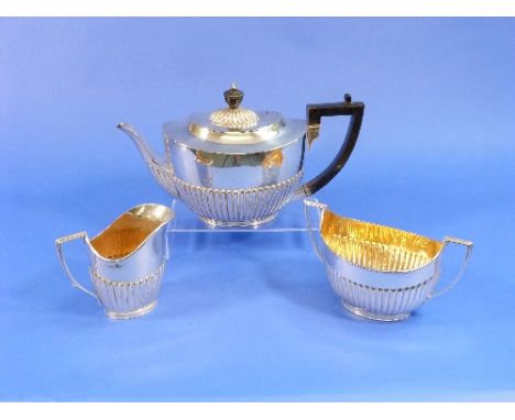 A near matched Victorian silver three piece Tea Set, the teapot and cream jug by Army & Navy Cooperative Society Ltd., hallma