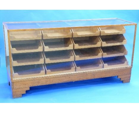 An Art Deco style vintage glazed Haberdashery Counter by Dudley & Co. Ltd., oak framed with sixteen graduated open tray drawe