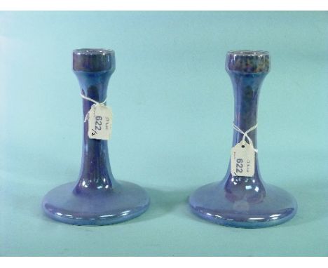 A pair of Ruskin pottery Candlesticks, with lustrous mottled light blue glazes, each with a circular cup above tapering stem 