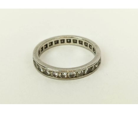 A DIAMOND SET ETERNITY RING, white metal shank set with round cut channel set diamonds, ring size 'N', 3.75 grams. 
